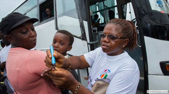 Vaccination d'un enfant dans une gare routière à Abidjan.