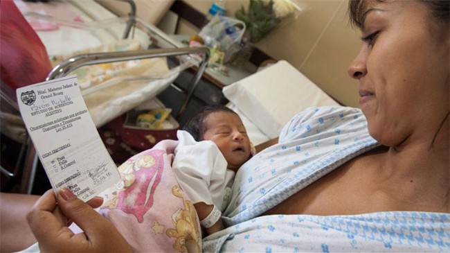 Une jeune maman admire son bébé en pleine santé. Il vient de passer un test pour dépister au plus tôt les problèmes auditifs dans le cadre d'une action du Rotary club de General Sarmiento de San Miguel en Argentine.