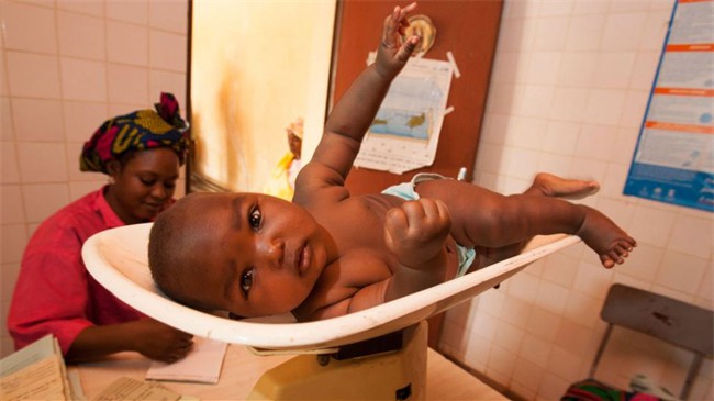 Dans un dispensaire parrainé par le Rotary à Loga au Niger, un bébé passe une visite médicale et est vacciné. Les membres du Rotary ont apporté plus de 700 000 dollars et des subventions de 270 000 dollars pour financer des actions durables au Niger en 2005-2006. 