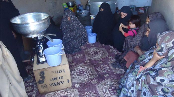 Des femmes observent le traitement du lait. Elles peuvent l'utiliser pour nourrir leur famille ou le vendre sur les marchés locaux. 